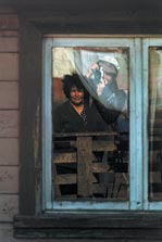 [ Image: Self-portrait of Neil Duncan, reflected in the window of the woman he was photographing ]